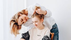 Mother standing talking to seated teenage daughter - help break free from a controlling relationship
