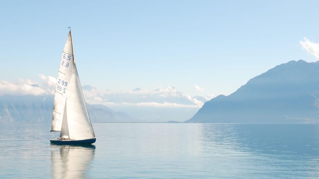 Sailboat gliding over peaceful waters on a sunny day, leaving bad karma in the past, living with a clean slate